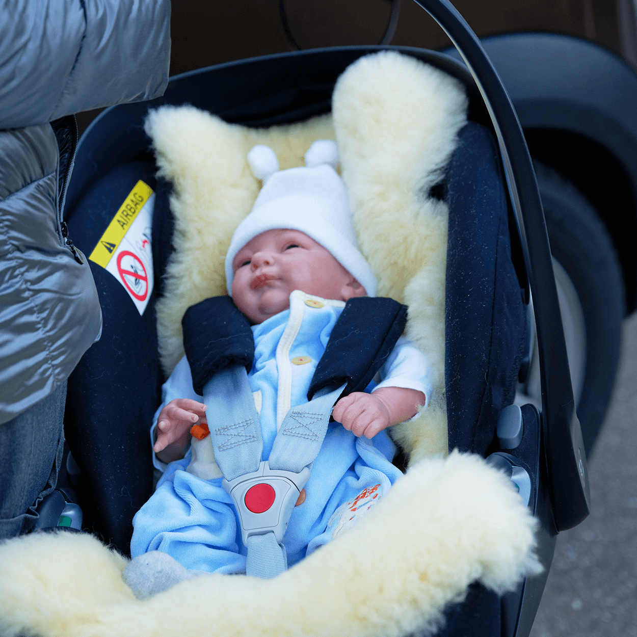 weißes Schaffell für Babys im Kindersitz